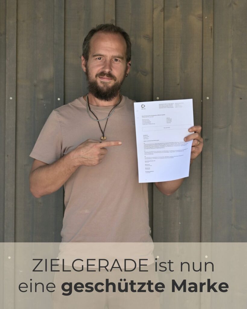 Marcel Bürge hält die offizielle IGE Bescheinigung für den Markenschutz der Wortmarke ZIELGERADE in den Händen